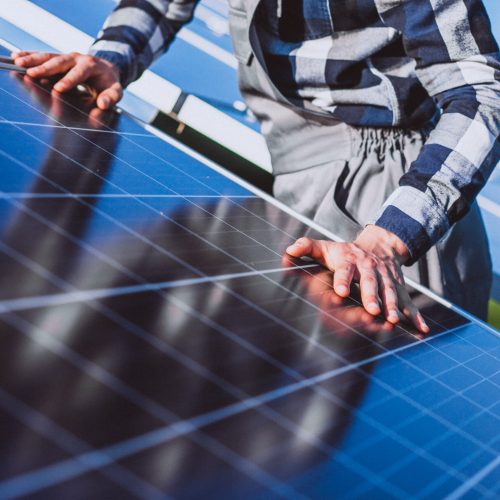Man worker in the firld by the solar panels